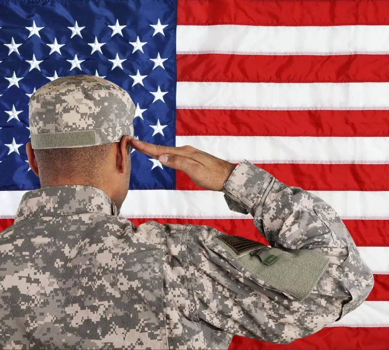 US service member saluting the American flag